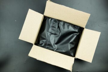 段ボールに入った、防水処理のため黒いビニールに入れられた荷物